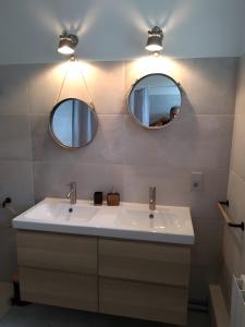 a bathroom with a white sink and two mirrors at Le Couvent in Lagardelle +22 photos