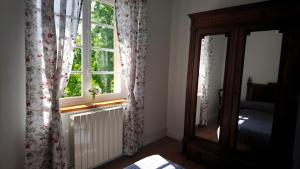 a room with a window with a radiator and a mirror at Le Couvent in Lagardelle