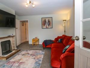 a living room with a red couch and a fireplace at Dakota in Holmrook