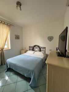 a bedroom with a bed and a flat screen tv at La Casetta in Lacco Ameno