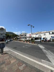 an empty street in a town with buildings and cars at La Casetta in Lacco Ameno