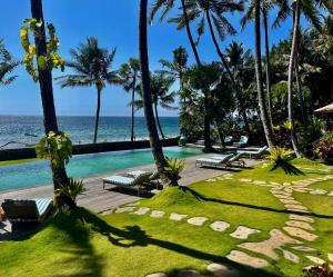a resort with a swimming pool and the ocean at Louka Beach Bali in Tianyar +81 photos