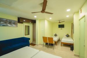 a room with two beds and a blue couch at Icon vista hotel in Tirupati +7 photos