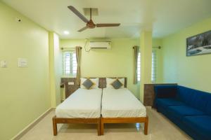 a bedroom with a bed and a blue couch at Icon vista hotel in Tirupati