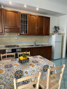 a kitchen with a table with a bowl of fruit on it at La Casetta in Lacco Ameno