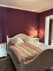 a bedroom with a bed with a purple wall at Gemütlicher Oase mit eigenen Bad in Zentrale, jedoch ruhige Lage in Mönchengladbach