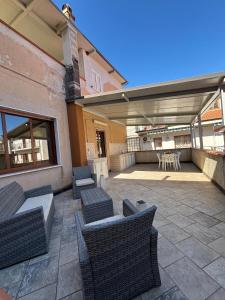 a patio with wicker chairs and a table and a table and chairs at La casa di Caliddu in Torrenova