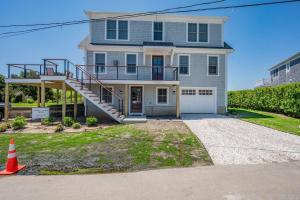 a large house with a staircase in front of it at Slow M'Ocean – A Fresh Take on Cape Calm in Chatham