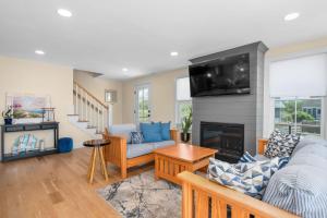 a living room with a couch and a fireplace at Slow M'Ocean – A Fresh Take on Cape Calm in Chatham +44 photos
