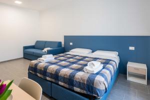 a bedroom with a blue bed and a blue couch at FEEL - Palazzo Ortelli in Bergamo