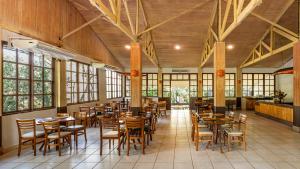 a dining room with tables and chairs and windows at Rio Quente Resorts - Eco Chalés in Rio Quente