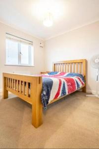 a bedroom with a wooden bed and a window at Bulkington Lodge Coventry - Affordable Cosy Double & En-Suite Rooms in Bulkington