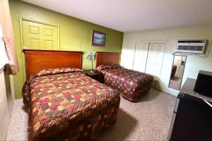 a hotel room with two beds and a tv at Riviera Motel Elba Near Enterprise US 84 in Elba