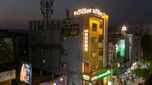 a tall yellow building with neon signs on it at Icon vista hotel in Tirupati