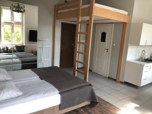 a bedroom with a bunk bed and a kitchen at Apartamenty Przy Plaży in Sopot