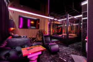 a room with a couch and a bed with purple lights at BDSM room Bydgoszcz z jacuzzi dużym tarasem i Balią zewnętrzną in Bydgoszcz
