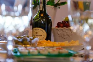 a bottle of wine sitting next to a plate of fruit at Dimora del Passaggio in Castiglion Fiorentino +14 photos
