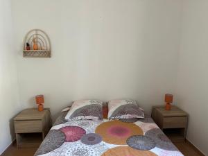 a bedroom with a bed with colorful pillows at Gîte Les 2 oliviers in Canet
