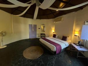 a bedroom with a bed and a table in a room at Tanas in Khawāsa