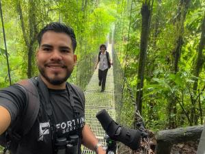 a man on a suspension bridge in the jungle with a woman walking behind at Rolling Green Oasis in Fortuna