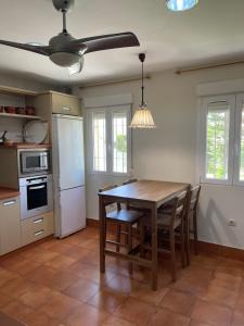 a kitchen with a table and chairs and a ceiling fan at La Casa de Luna Lunera in Córdoba