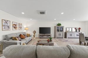a living room with a couch and a tv at Apartamento Cabine by Algarve Holidays in Quarteira