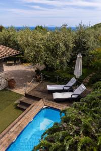 a swimming pool with two lounge chairs and an umbrella at Villa Privata con Giardino e Piscina in Trivio