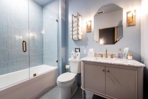 a bathroom with a toilet and a sink and a shower at Hollyhock Suite 406 in Louisville