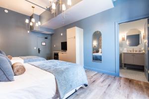two beds in a room with blue walls at Hollyhock Suite 406 in Louisville