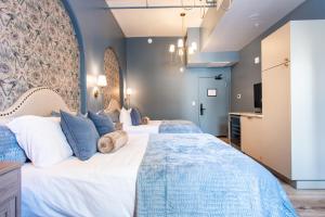 two beds in a bedroom with blue walls at Hollyhock Suite 406 in Louisville