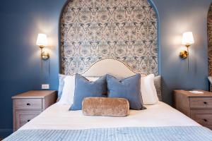 a bedroom with a large bed with blue walls at Hollyhock Suite 406 in Louisville