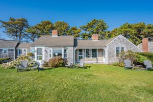 a house with chairs in the yard at Lost at Seaside – Your Cozy Coastal Hideaway in South Yarmouth