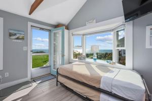 a bedroom with a bed and two large windows at Lost at Seaside – Your Cozy Coastal Hideaway in South Yarmouth