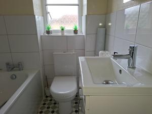 a white bathroom with a toilet and a sink at Pulteney Road Apartment in Bath