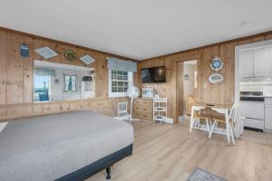 a bedroom with a bed and a kitchen and a desk at Oceans Edge: Drift, Dream, Repeat in South Yarmouth
