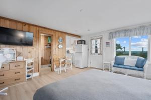 a bedroom with a bed and a kitchen with a refrigerator at Oceans Edge: Drift, Dream, Repeat in South Yarmouth +26 photos