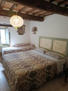 a bedroom with two beds and a chandelier at B&B Paradiso in Gubbio