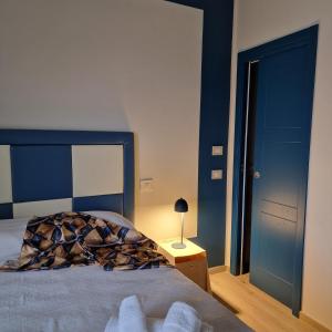a bedroom with a bed and a blue wall at marte rooms in Centola