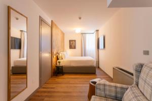 a room with two beds and a couch and a mirror at Le Mallet, Courmayeur, Alpine Homesuite in Courmayeur +109 photos