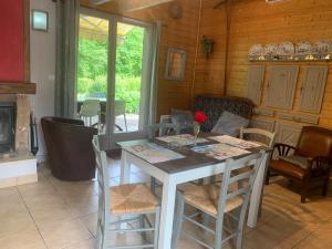 a dining room with a table and chairs and a fireplace at Chalet Les Ammonites 2 chambres en Franche Comte au calme dans la nature in Nans-sous-Sainte-Anne