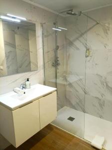 a white bathroom with a shower and a sink at Iberflat Apartamentos Marynton in Benicarló +49 photos