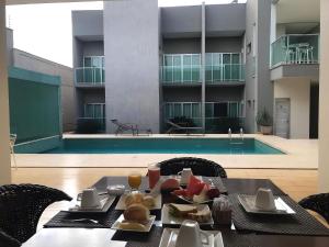 a table with food on it in front of a pool at Oásis Hotel in Araguaína