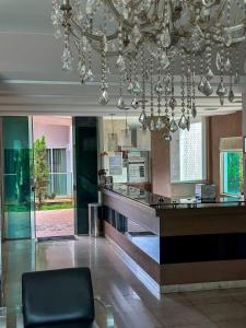 a lobby with a bar with a chandelier at Oásis Hotel in Araguaína