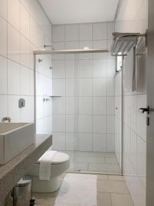 a white bathroom with a toilet and a sink at Oásis Hotel in Araguaína +13 photos