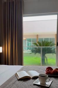 a bedroom with a bed with a book and a bowl of fruit at Oásis Hotel in Araguaína