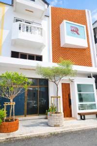 a building with two trees in front of it at R4R RoomforRest Boutique Hotel Bangsaen Beach in Ban Laem Thaen