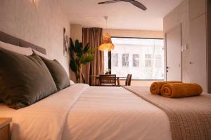 a bedroom with a large white bed with towels on it at SLEEP INN - Kyoto Suites South Antwerp in Antwerp