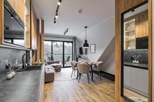 a kitchen and living room with a table and chairs at BANIA BLACK MOUNTAIN I basen & spa in Białka Tatrzańska