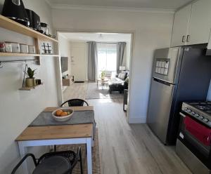 a small kitchen with a table and a refrigerator at 1 bed room - Cozy unit in Cheltenham