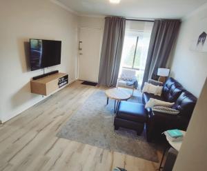 a living room with a couch and a table at 1 bed room - Cozy unit in Cheltenham